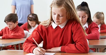 female student completing exam in uniform