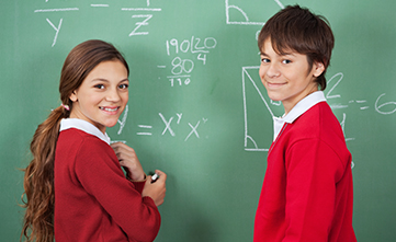 students at chalkboard working out maths problems