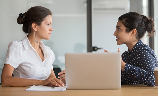 two females at a desk doing assessment data analysis